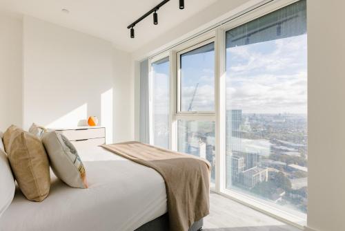 a bedroom with a white bed and a large window at CitySpace Acton in London