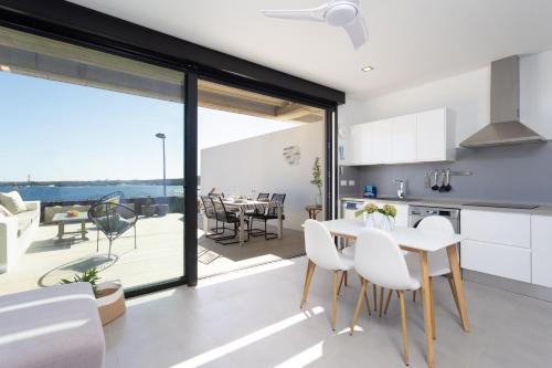 - une cuisine et une salle à manger avec une table et des chaises dans l'établissement Home2Book Design & Breathtaking Sea Views El Porís, à Poris de Abona