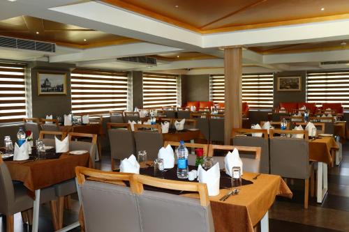 a dining room with tables and chairs in a restaurant at Capital Park Residency in Trivandrum