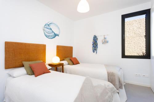 A bed or beds in a room at Home2Book Design & Breathtaking Sea Views El Porís