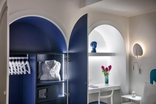 a room with a blue refrigerator and a table at Pazziella Garden & Suites in Capri