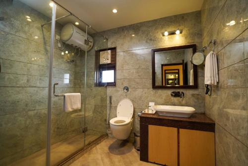 a bathroom with a toilet and a shower and a sink at Hotel The Twin Towers in Shimla