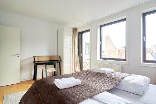 a bedroom with a bed with two towels on it at Stylish 2BR w Private Balcony in CPH City Centre in Copenhagen