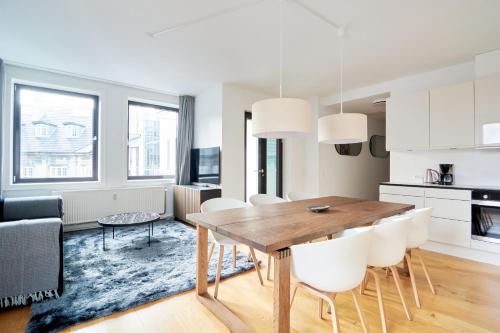 a kitchen and dining room with a wooden table and chairs at Stylish 2BR w Private Balcony in CPH City Centre in Copenhagen