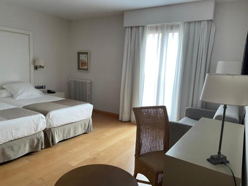 a hotel room with a bed and a desk and chair at Parador de Puebla de Sanabria in Puebla de Sanabria