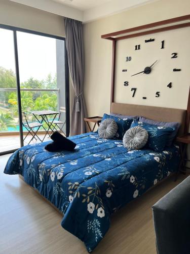a bedroom with a bed with a large clock on the wall at Timurbay Seafront Seaview & Poolview Suite with Wi-Fi in Kuantan