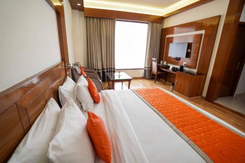 a hotel room with a bed and a television at Hotel The Twin Towers in Shimla