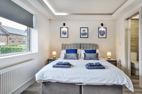 a bedroom with a large bed with two pillows on it at Large, Modern Apartment with En-suites, Wifi, Parking by Ark SA in Sheffield