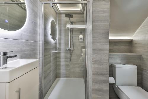 a bathroom with a shower and a toilet and a sink at Large, Modern Apartment with En-suites, Wifi, Parking by Ark SA in Sheffield