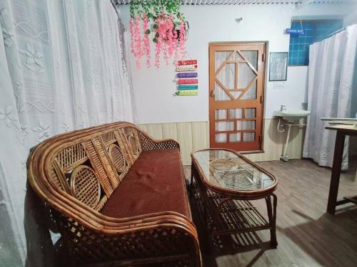 een kamer met een bank, een tafel en een deur bij Green Diamond Homestay in Dehradun