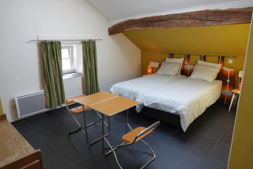 胡法利茲的住宿－Coeur de Boeur，卧室配有一张床和一张桌子及椅子