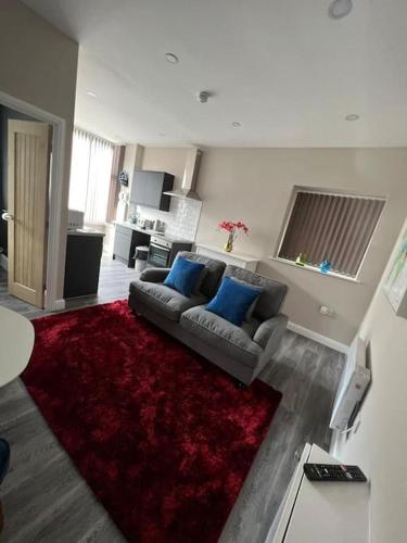 a living room with a couch and a red rug at Velveteen by The V Group in Blackpool