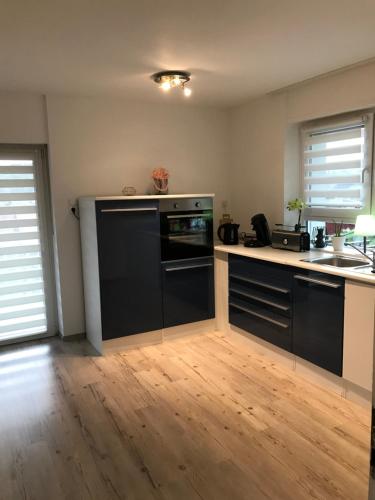 a kitchen with black appliances and a wooden floor at Sulzberg in Lahr