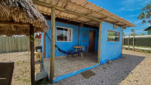 a blue house with a hammock in front of it at CÉU DE AGARTHA Retiros e Vivências in Alto Paraíso de Goiás