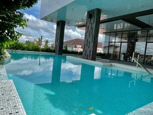 a large swimming pool in front of a building at Tonaoi Grand Hotel in Hat Yai