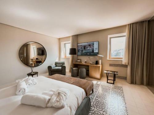 um quarto de hotel com uma cama grande e um espelho em Ognissanti Restaurant Spa Hotel Rooftop em Trani
