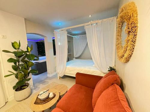 sala de estar con sofá y cama en L'instant Bornéo Superbe appartement avec jacuzzi, en Liancourt