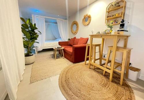 a living room with a red couch and a table at L'instant Bornéo Superbe appartement avec jacuzzi in Liancourt