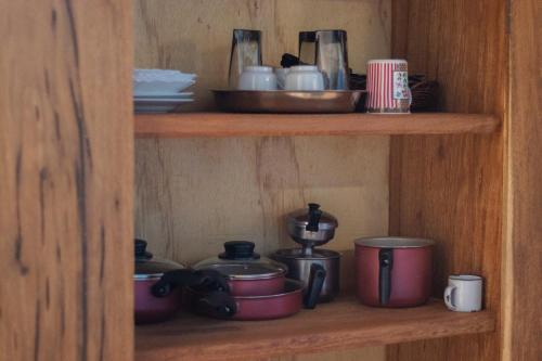a wooden shelf with pots and pans on it at CÉU DE AGARTHA Retiros e Vivências in Alto Paraíso de Goiás