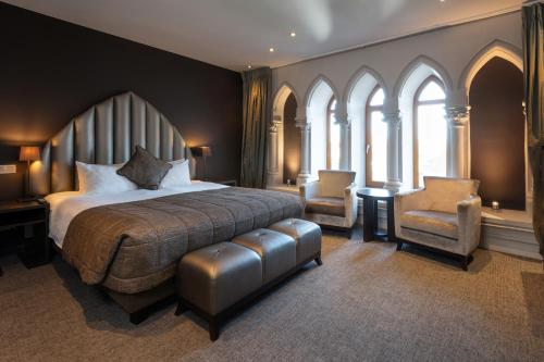 a bedroom with a large bed and two chairs at Martin's Patershof in Mechelen