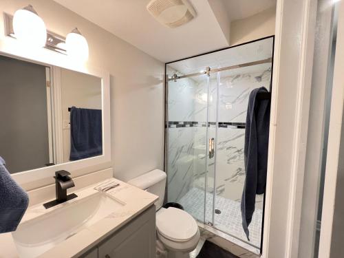 a bathroom with a shower and a toilet and a sink at Beautiful Vacation Home near Toronto Airport in Mississauga
