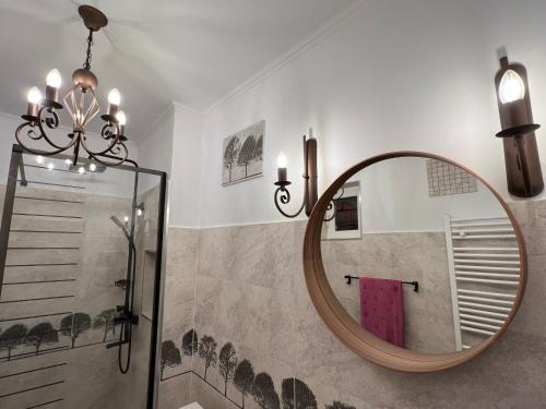 a bathroom with a round mirror and a shower at The View Sinaia-Busteni in Buşteni