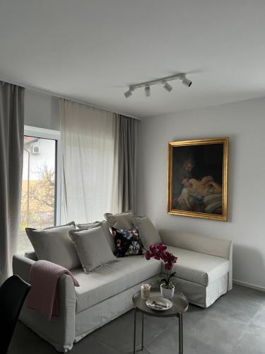 a living room with a couch and a painting at Apartments Lily in Ljubljana