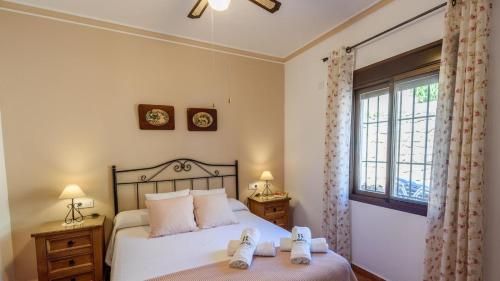 Un dormitorio con una cama y una ventana con zapatos. en Villa Los Rosales El Gastor by Ruralidays, en El Gastor