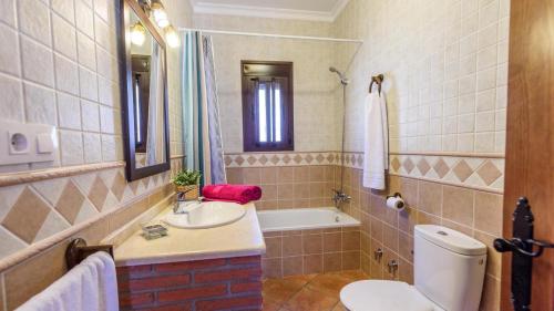 y baño con aseo, lavabo y bañera. en Villa Los Rosales El Gastor by Ruralidays, en El Gastor