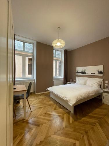 a bedroom with a bed and a desk and windows at Schei Central Studios in the heart of Brasov in Braşov