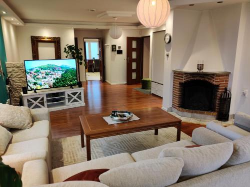 uma sala de estar com sofás, uma televisão e uma lareira em Luxury accommodation 130 m2 em Katrineholm