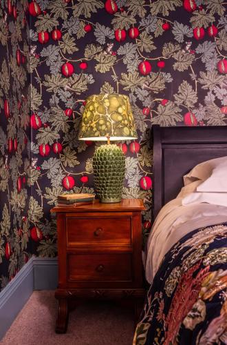 a lamp on a night stand next to a bed at The Portobello Hotel in London