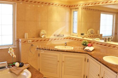 a bathroom with two sinks and a large mirror at Villa Felicity in Porches