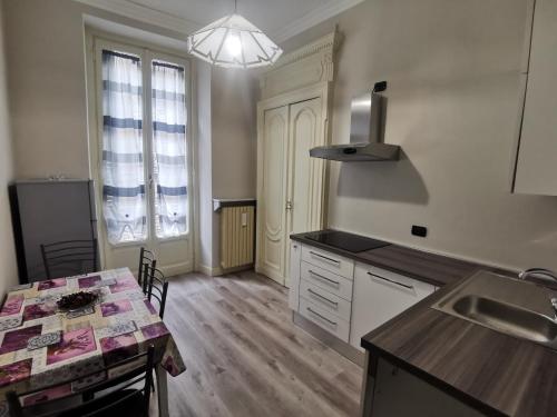 a kitchen with a sink and a table with a counter top at LA QUALITA' AL QUADRATO in Turin