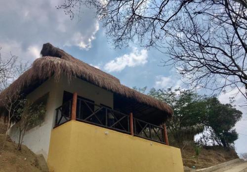 a hut with a thatched roof on top of it at Kamajorú Ecohabitat in Tubará