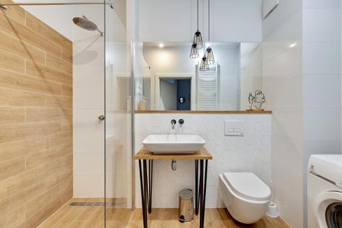 uma casa de banho com um lavatório e um WC em Modern Old Town - Apartament w centrum Gdańska by Grand Apartments em Gdansk