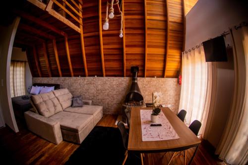 a living room with a couch and a table at Chale em Curitiba - Chales Portugal in Campo Magro