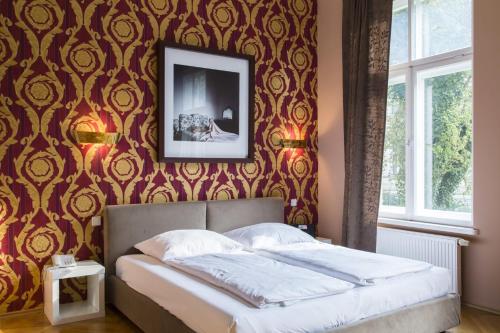 a bedroom with a bed and a picture on a wall at Hotel Residenz Begaswinkel in Berlin