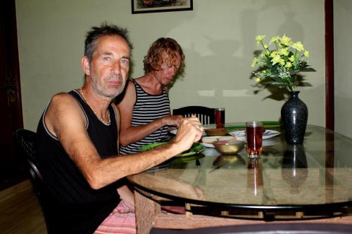 a man and a woman sitting at a table at Sajeev Home Stay in Cherai Beach