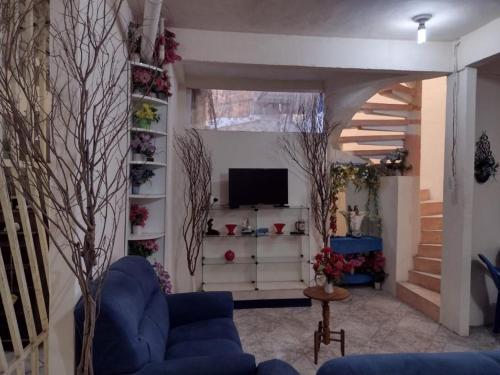 salon z niebieską kanapą i telewizorem w obiekcie Pousada da Vovó w mieście Bragança