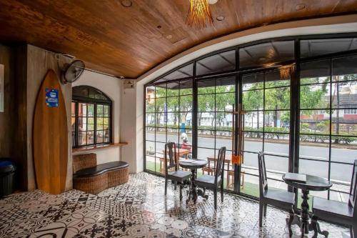 a room with two tables and chairs and windows at WHITE BANANA Manila - NEW in Manila