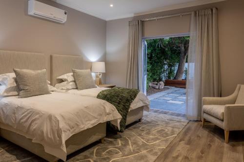 a bedroom with two beds and a sliding glass door at Villa Stellenbosch in Stellenbosch