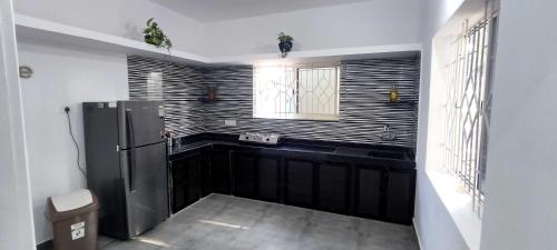 a kitchen with a refrigerator and a window at Ola Goa in Mandrem