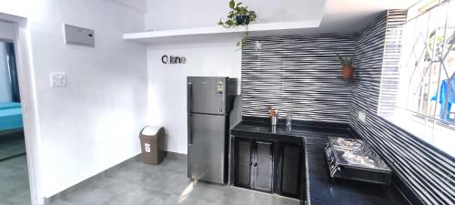 a kitchen with a stainless steel refrigerator in a room at Ola Goa in Mandrem