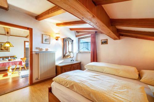 a bedroom with two beds and a table in a room at Adang Ferienwohnung Mutspitz in Tirolo