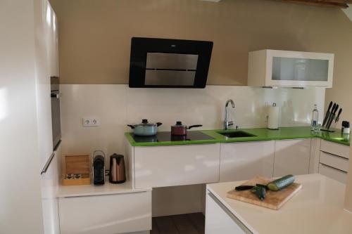 a kitchen with white cabinets and a green counter top at Wohnung bei Façon in Eckernförde