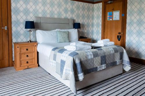 a bedroom with a large bed with towels on it at The Inn on the Moor Hotel in Goathland