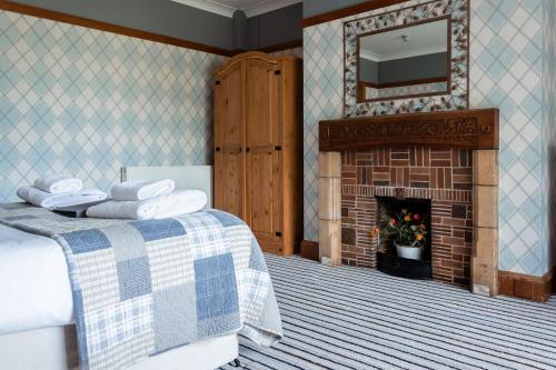 a bedroom with a bed with a fireplace and a mirror at The Inn on the Moor Hotel in Goathland