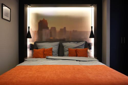ミュルハイム・アン・デア・ルールにあるJustStay Mülheim an der Ruhrのベッドルーム1室(オレンジ色の枕が付いたベッド1台付)