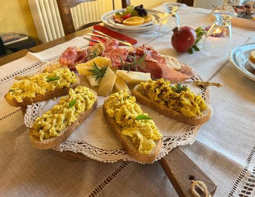 a table with bread with scrambled eggs on it at B&B La Casa Del Riccio in Cinto Euganeo